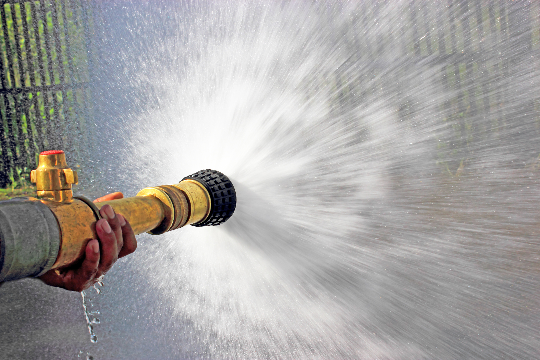 A firefighter uses a fire hose to spray water during a training exercise.