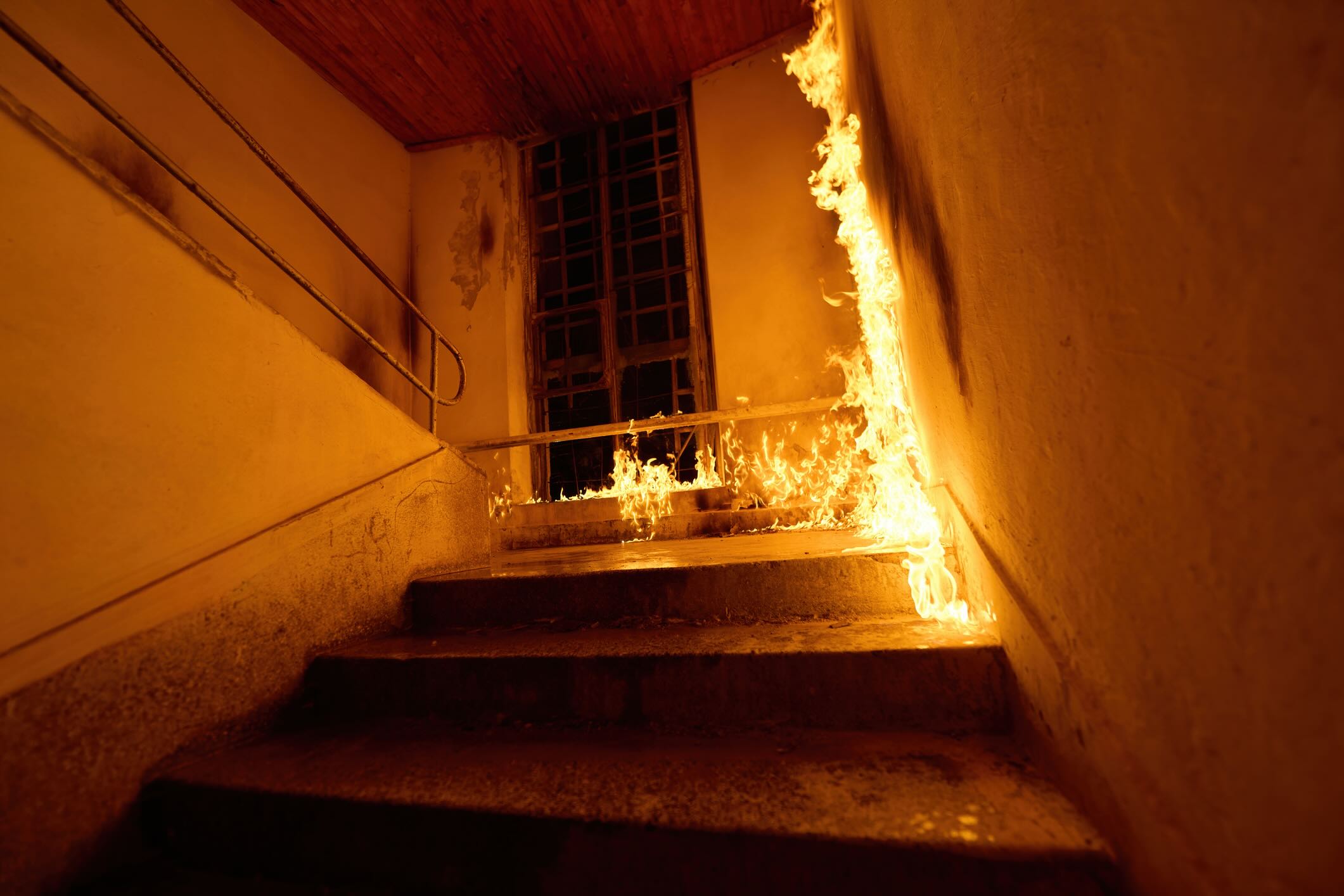 A staircase is engulfed in flames, creating a dangerous and hazardous situation. This image can be used to illustrate fire safety, emergency response, or the aftermath of a fire accident in a building.