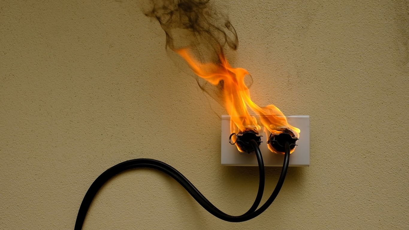 On fire electric wire plug Receptacle on the concrete wall background