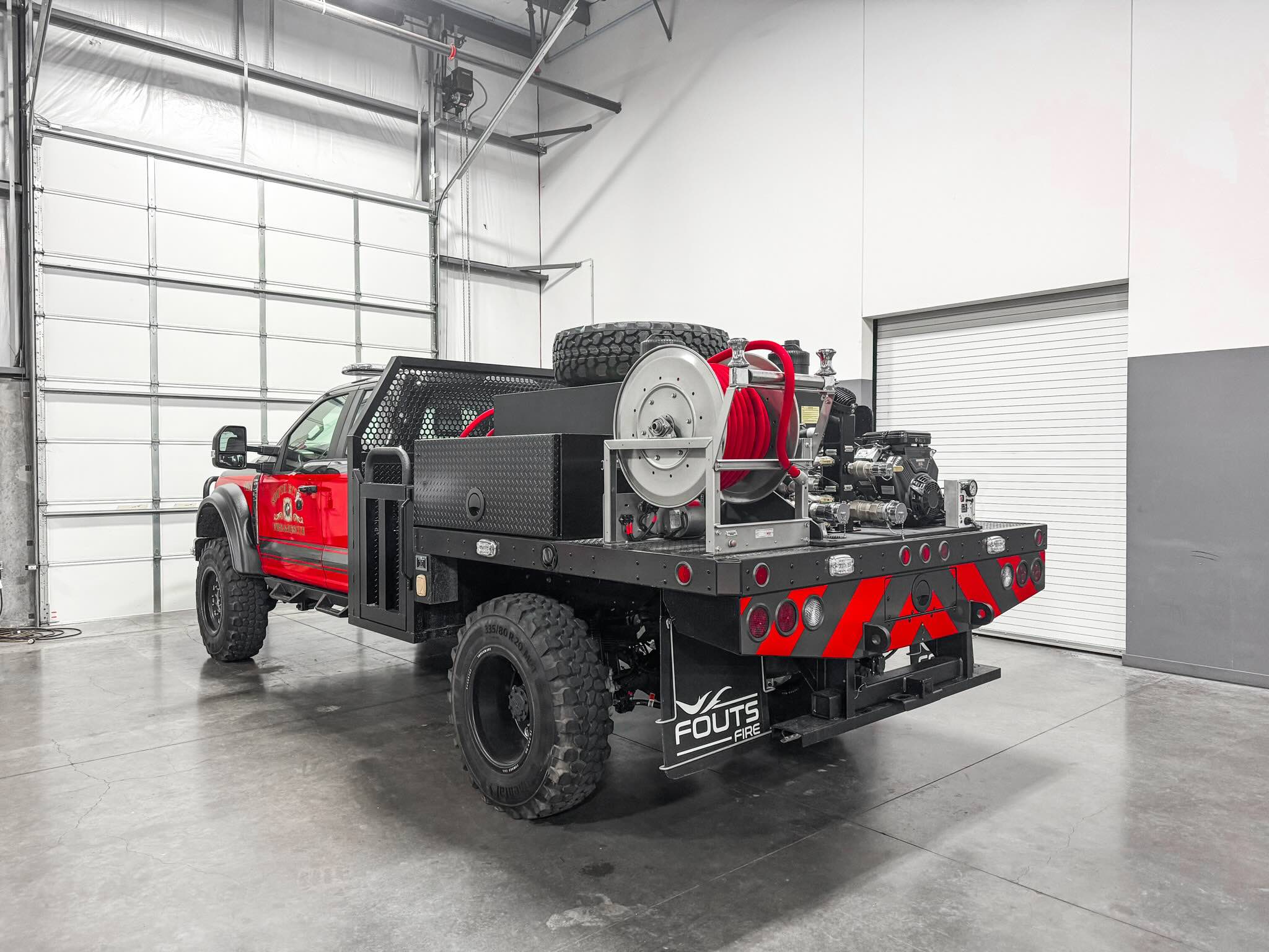 Back view of a Fouts Fire apparatus personalized for South Ector Fire & Rescue parked in a garage.